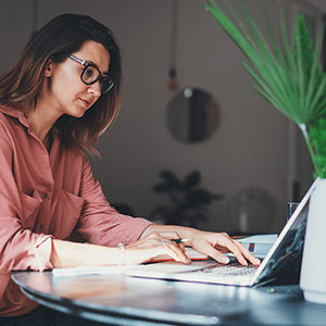 Woman navigating laptop with keyboard while sitting at desk